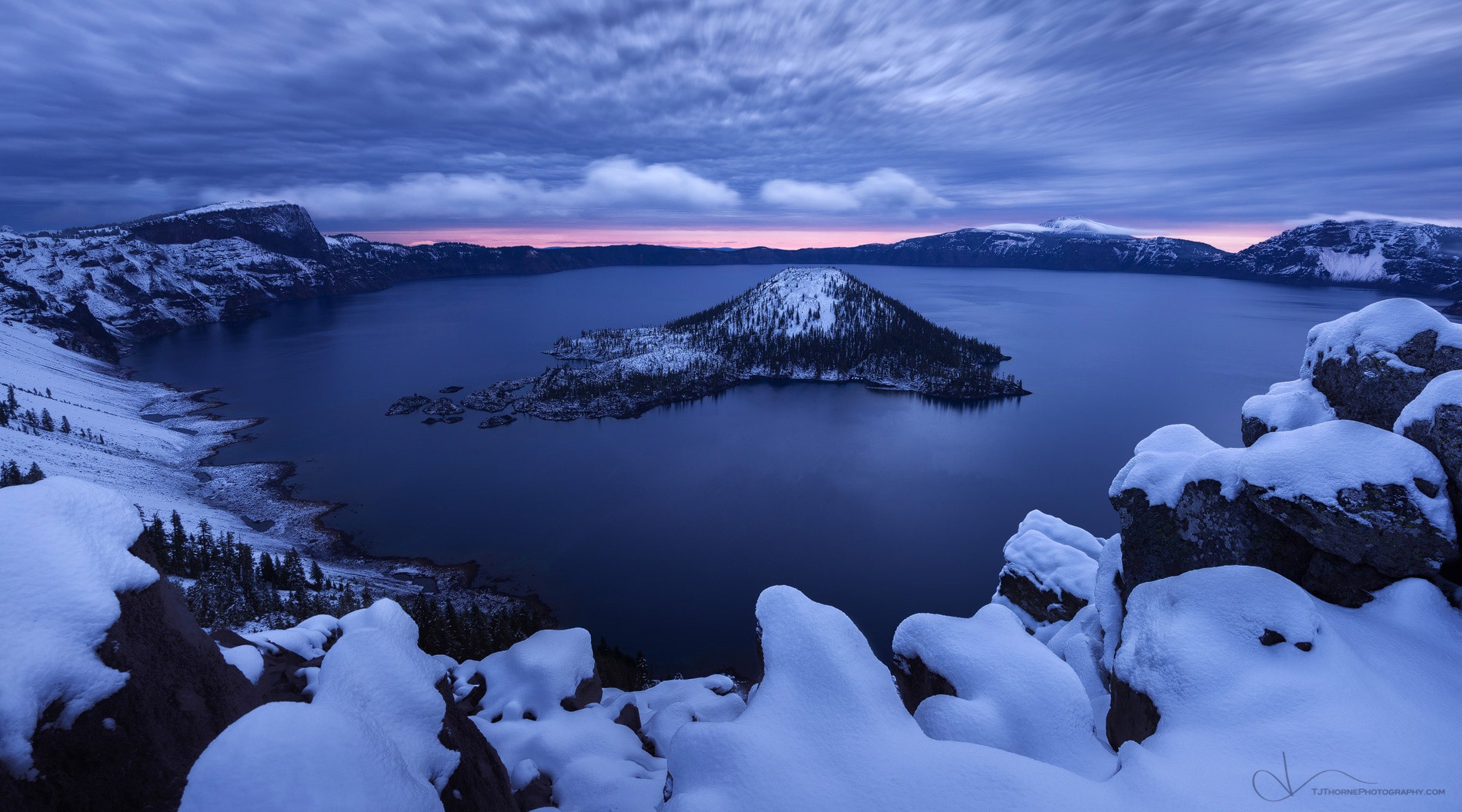 Sunrise on the morning of the first snow of the season at Crater Lake Lake National Park, Oregon. Crater Lake National Park is...